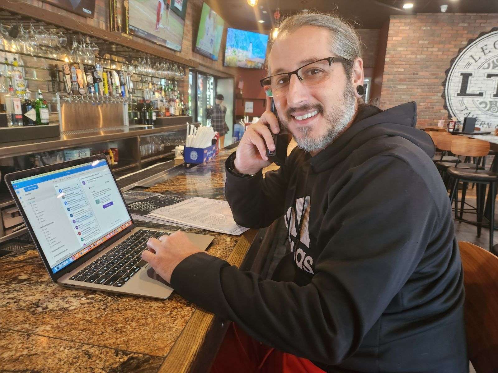 Joseph Charnin working on a laptop while taking a client call